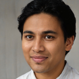 Joyful latino young-adult male with short  black hair and brown eyes