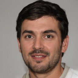 Joyful white young-adult male with short  black hair and brown eyes