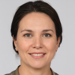 Joyful white adult female with medium  brown hair and brown eyes