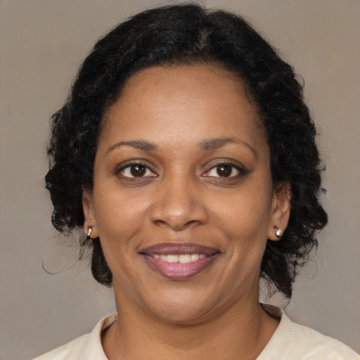 Joyful black adult female with medium  brown hair and brown eyes