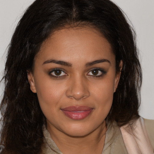 Joyful black young-adult female with long  brown hair and brown eyes