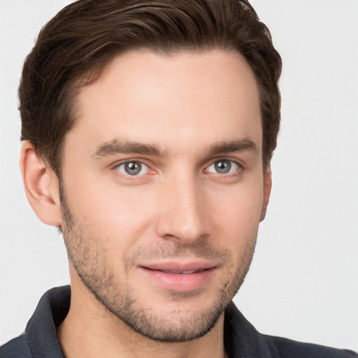 Joyful white young-adult male with short  brown hair and grey eyes