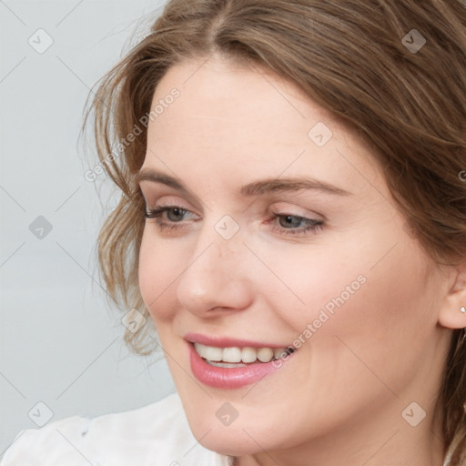 Joyful white young-adult female with long  brown hair and blue eyes