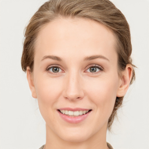 Joyful white young-adult female with short  brown hair and green eyes