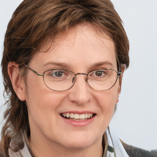 Joyful white adult female with medium  brown hair and blue eyes