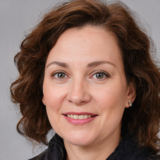 Joyful white adult female with medium  brown hair and brown eyes