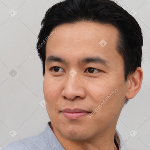 Joyful asian young-adult male with short  brown hair and brown eyes