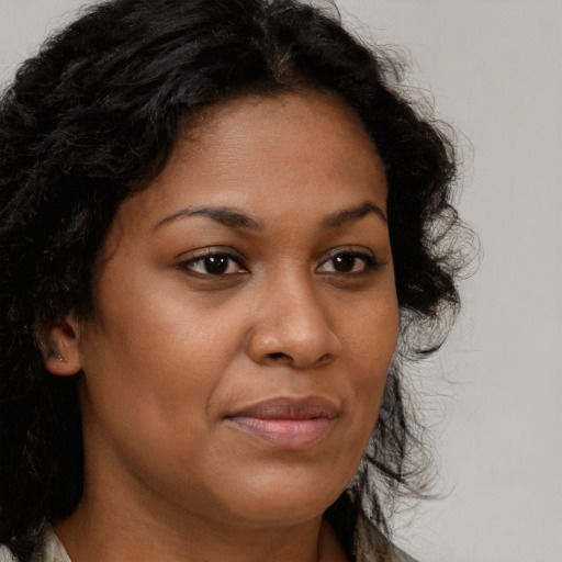 Joyful black young-adult female with long  brown hair and brown eyes