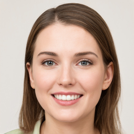 Joyful white young-adult female with long  brown hair and green eyes