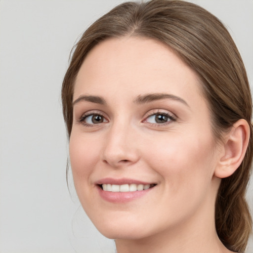 Joyful white young-adult female with long  brown hair and blue eyes