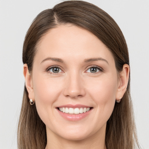 Joyful white young-adult female with long  brown hair and grey eyes