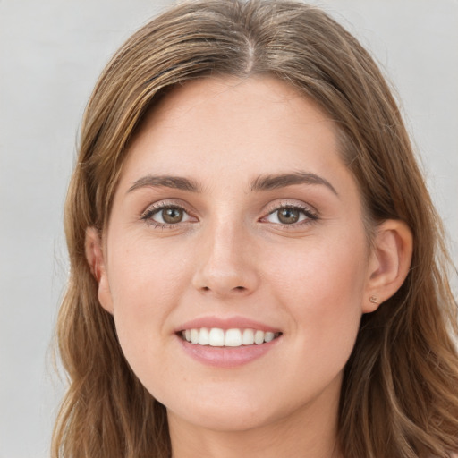 Joyful white young-adult female with long  brown hair and green eyes