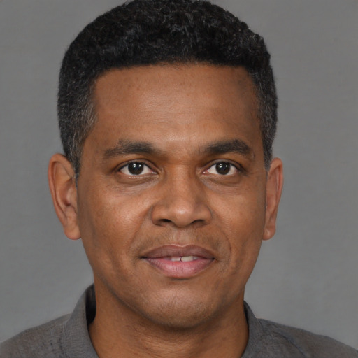 Joyful black adult male with short  brown hair and brown eyes