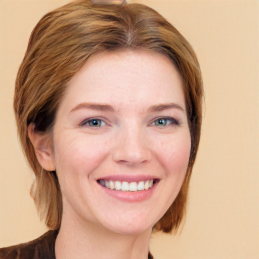 Joyful white young-adult female with long  brown hair and blue eyes