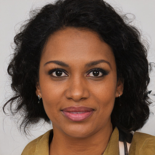 Joyful black young-adult female with long  brown hair and brown eyes