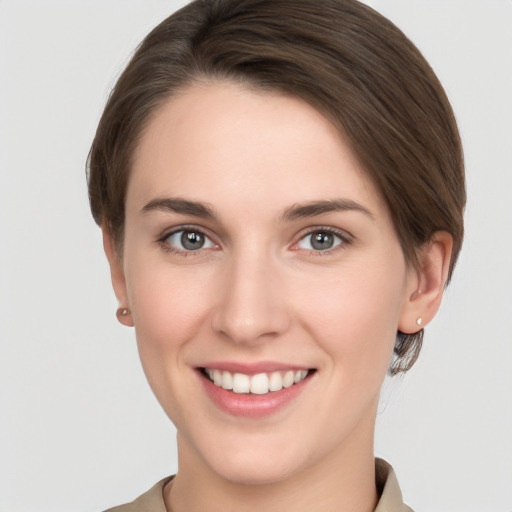 Joyful white young-adult female with short  brown hair and grey eyes