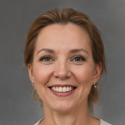 Joyful white adult female with medium  brown hair and grey eyes