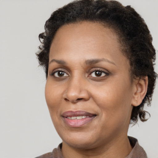 Joyful black adult female with short  brown hair and brown eyes