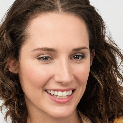 Joyful white young-adult female with long  brown hair and green eyes