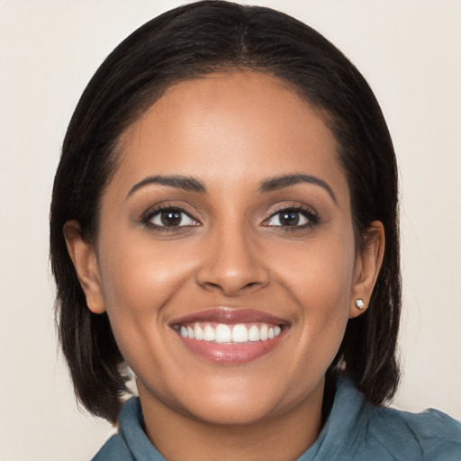 Joyful latino young-adult female with long  brown hair and brown eyes