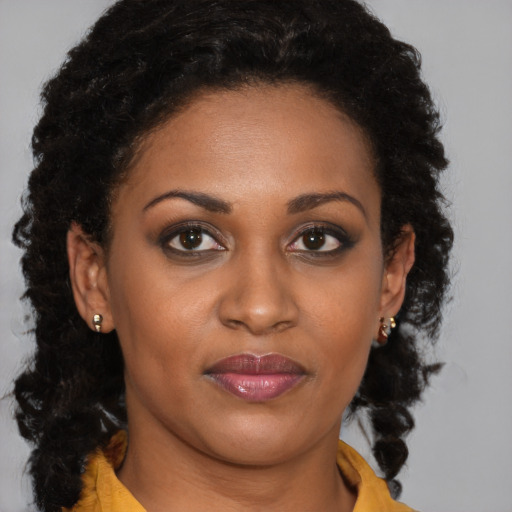 Joyful black young-adult female with long  brown hair and brown eyes