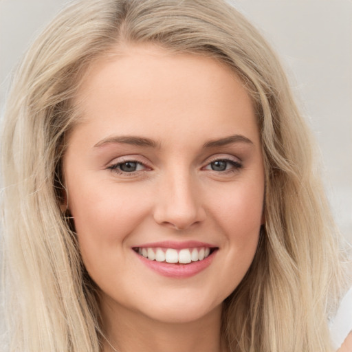 Joyful white young-adult female with long  brown hair and blue eyes