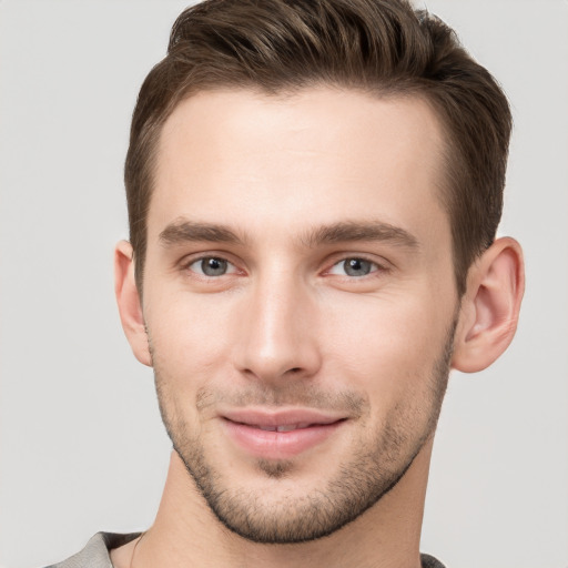 Joyful white young-adult male with short  brown hair and grey eyes