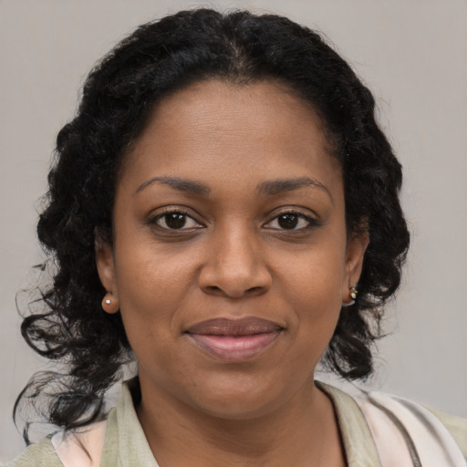 Joyful black young-adult female with medium  brown hair and brown eyes