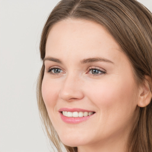 Joyful white young-adult female with long  brown hair and grey eyes