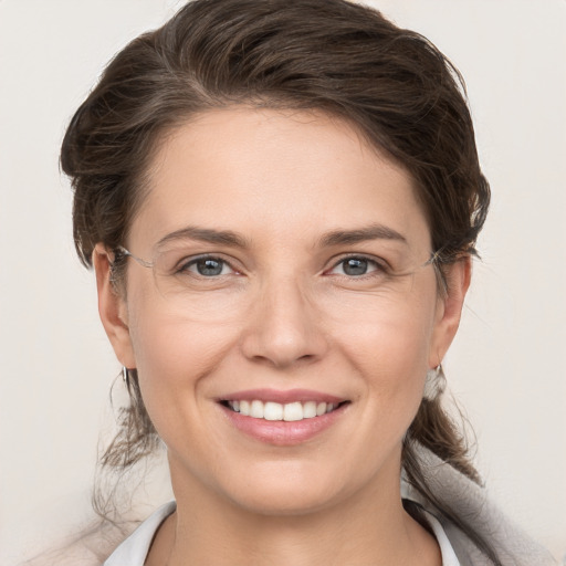 Joyful white young-adult female with medium  brown hair and grey eyes