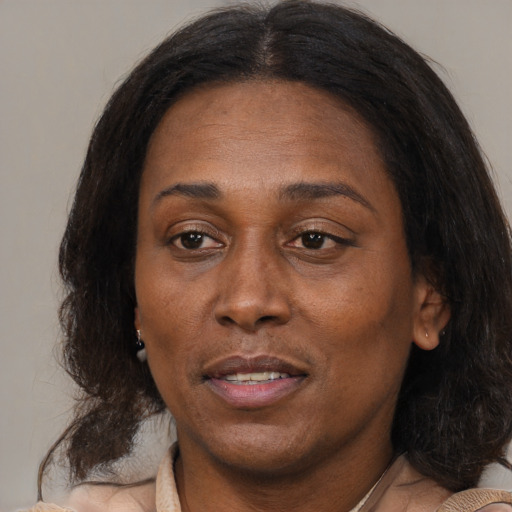 Joyful black adult female with medium  brown hair and brown eyes