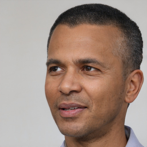 Joyful latino adult male with short  black hair and brown eyes