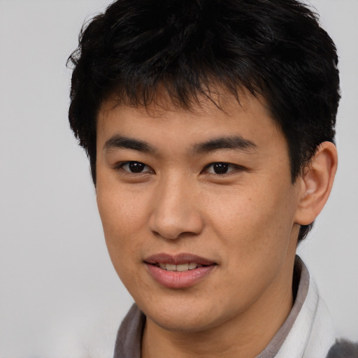 Joyful asian young-adult male with short  brown hair and brown eyes