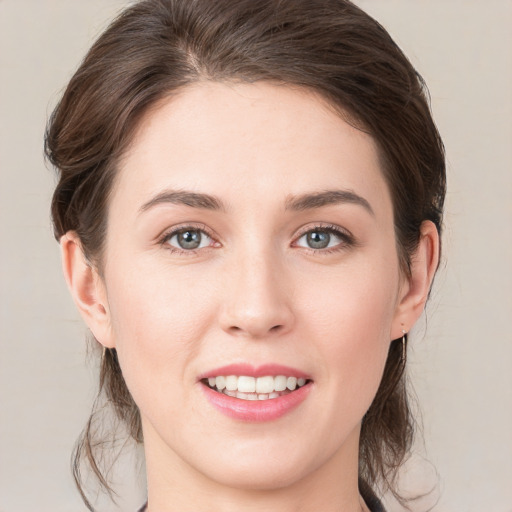 Joyful white young-adult female with medium  brown hair and grey eyes