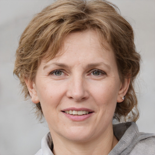 Joyful white adult female with medium  brown hair and blue eyes