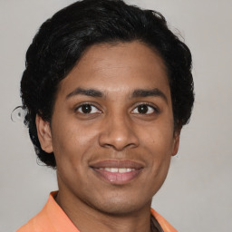 Joyful latino young-adult male with short  brown hair and brown eyes