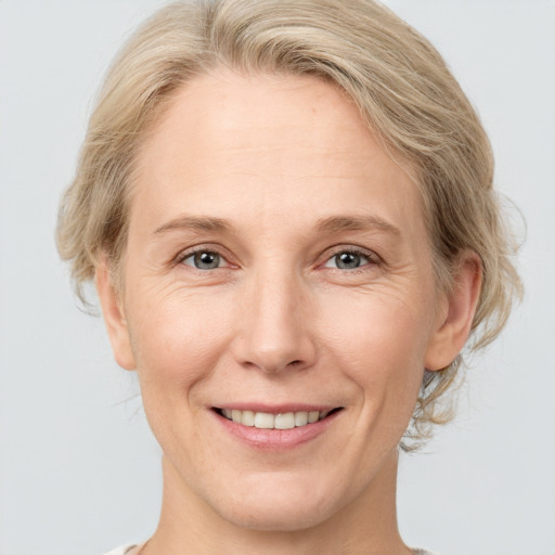 Joyful white adult female with medium  brown hair and grey eyes