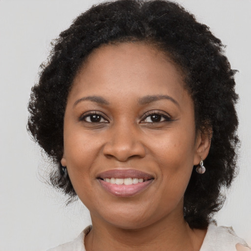 Joyful black adult female with short  brown hair and brown eyes