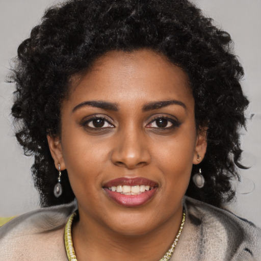 Joyful black young-adult female with long  black hair and brown eyes