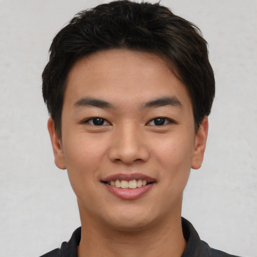 Joyful asian young-adult male with short  brown hair and brown eyes