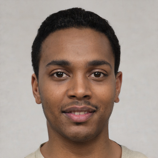 Joyful black young-adult male with short  black hair and brown eyes