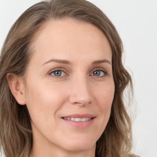 Joyful white young-adult female with long  brown hair and blue eyes