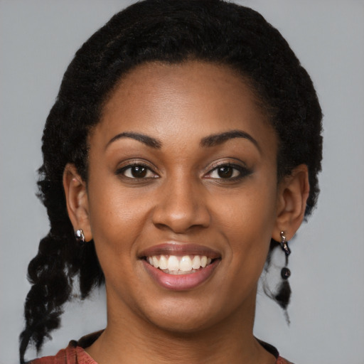 Joyful black young-adult female with medium  brown hair and brown eyes