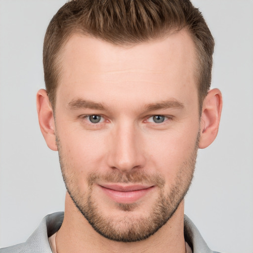 Joyful white young-adult male with short  brown hair and grey eyes