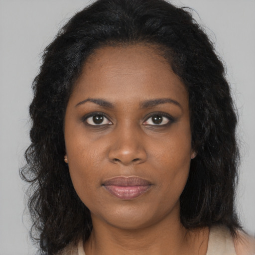 Joyful black young-adult female with long  brown hair and brown eyes