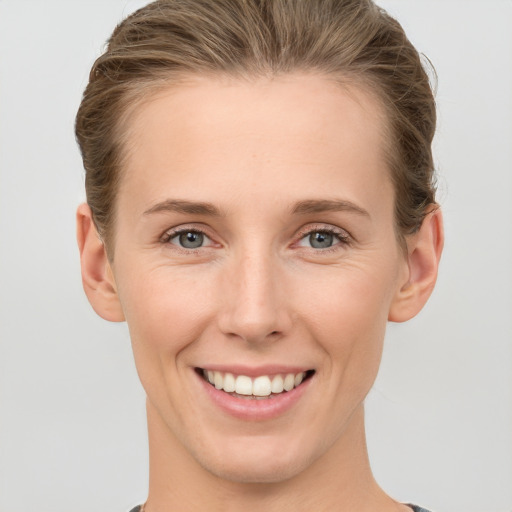 Joyful white young-adult female with short  brown hair and grey eyes