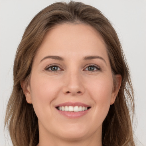 Joyful white young-adult female with long  brown hair and grey eyes