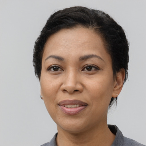 Joyful latino adult female with short  brown hair and brown eyes