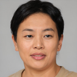 Joyful asian young-adult female with short  brown hair and brown eyes