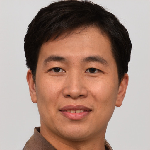 Joyful asian young-adult male with short  brown hair and brown eyes